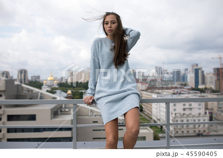 Attractive woman stands on a terrace overlooking the city. Attractive woman stands on a terrace overlooking the city. 45590405