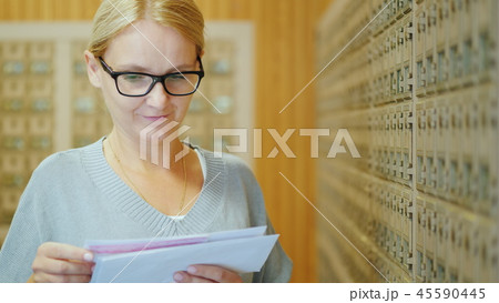 Portrait of a young stylish woman with a bundle of letters in her hands in the post office Portrait of a young stylish woman with a bundle of letters in her hands in the post office 45590445