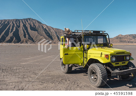 Tourist woman standing on door yellow four wheel Tourist woman standing on door yellow four wheel 45591598