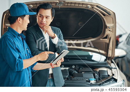 Men discussing the problem of car motor 45593304
