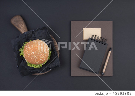 Big hamburger with sesame seeds on a black background. Fast food and free space for text. Notebook Big hamburger with sesame seeds on a black background. Fast food and free space for text. Notebook 45593305