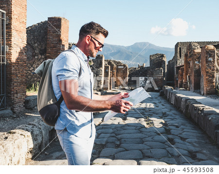 Handsome man in sunglasses looking at a map Handsome man in sunglasses looking at a map 45593508