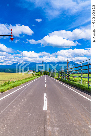 北海道 上富良野 夏空の一本道の写真素材