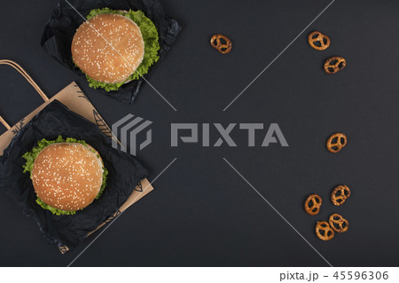 Two hamburger on a black background for lunch. Fast food and snacks. Free space for text. Copy space Two hamburger on a black background for lunch. Fast food and snacks. Free space for text. Copy space 45596306