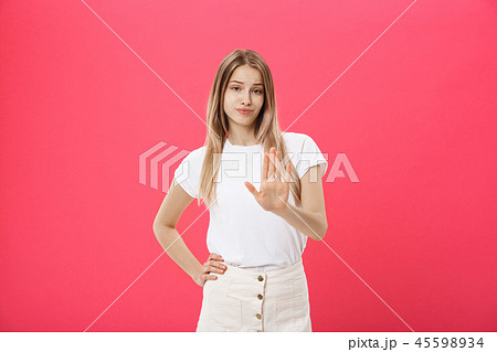 Displeased female model with freckled skin, raises eyebrows and frowns face, makes refusal gesture 45598934