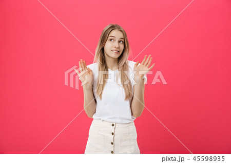 Displeased female model with freckled skin, raises eyebrows and frowns face, makes refusal gesture Displeased female model with freckled skin, raises eyebrows and frowns face, makes refusal gesture 45598935