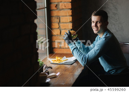 Man in black gloves takes a burger in his hands. Vegetarian burger with vegetables. Fresh healthy 45599260