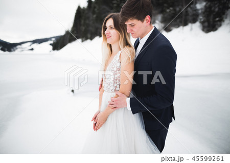 Wedding couple on the nature is hugging each other. Beautiful model girl in white dress. Man in suit 45599261
