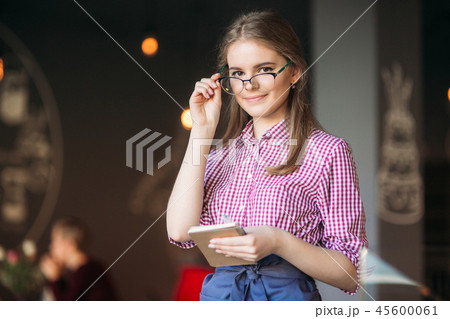 Portrait of a beautiful friendly waitress in glasses with notepapers and pen ready to take your Portrait of a beautiful friendly waitress in glasses with notepapers and pen ready to take your 45600061