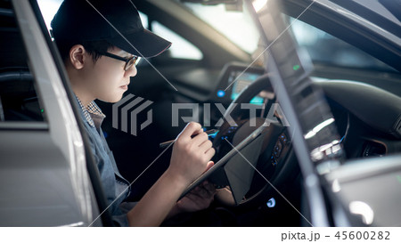 Asian auto mechanic checking the car using tablet Asian auto mechanic checking the car using tablet 45600282