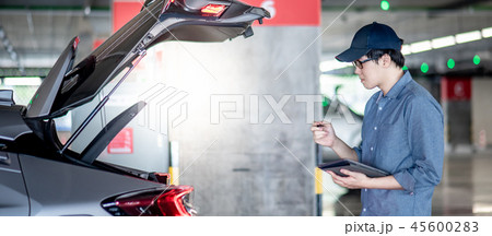 Asian auto mechanic checking the car using tablet 45600283