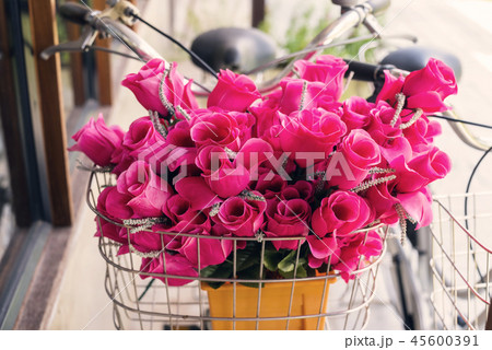 Pink flowers on front bicycle basket Pink flowers on front bicycle basket 45600391