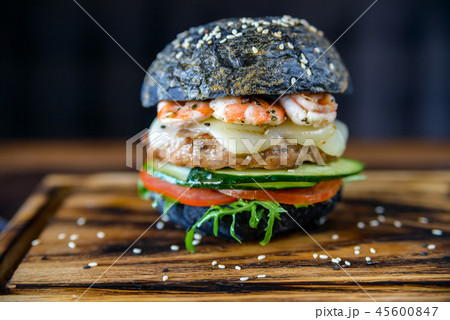 Black burger with prawns on wooden board 45600847