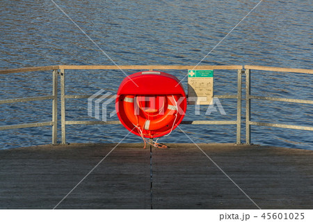 Red lifebuoy hanging on wooden pier, Jordan pond Red lifebuoy hanging on wooden pier, Jordan pond 45601025