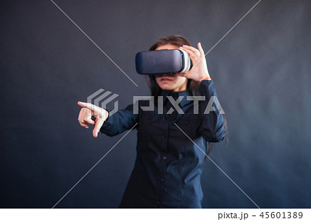 Happy woman on a black background in the studio gets the experience of using VR-glasses virtual Happy woman on a black background in the studio gets the experience of using VR-glasses virtual 45601389