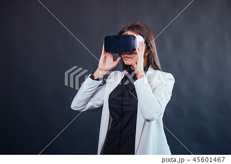 Happy woman on a black background in the studio gets the experience of using VR-glasses virtual Happy woman on a black background in the studio gets the experience of using VR-glasses virtual 45601467