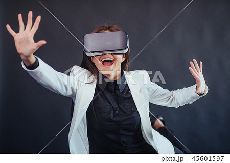 Happy woman on a black background in the studio gets the experience of using VR-glasses virtual Happy woman on a black background in the studio gets the experience of using VR-glasses virtual 45601597