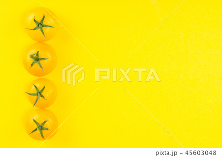 Bright yellow and red tomatoes on colored background 45603048