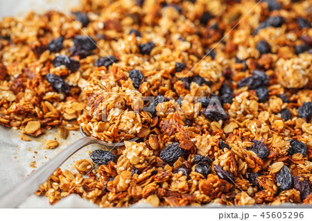 Baked granola with raisins on baking sheet. Baked granola with raisins on baking sheet. 45605296