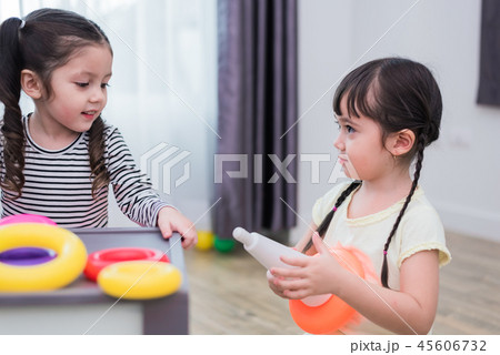 Two little girls playing small toy balls in home together. Educa 45606732