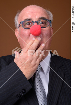 Overweight senior businessman wearing red clown nose Overweight senior businessman wearing red clown nose 45609813
