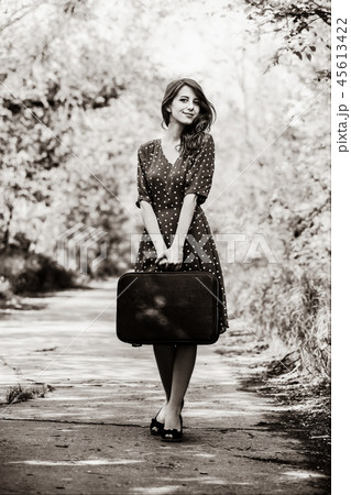 girl with travel suitcase staying on rural road girl with travel suitcase staying on rural road 45613422