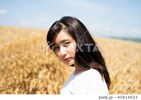 麦畑と女性 ポートレートの写真素材