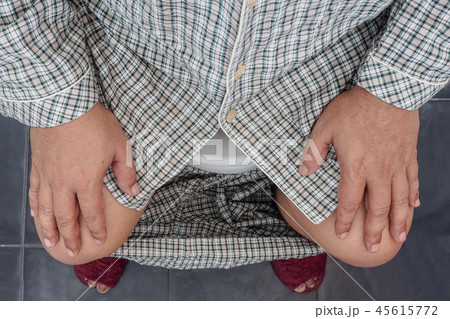 Close up of man sitting on toilet seat 45615772