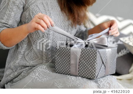 Young woman opens the box with a Christmas present Young woman opens the box with a Christmas present 45622010