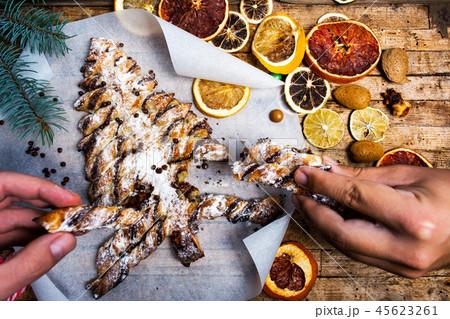Hands grabbing christmas tree pastry dessert Hands grabbing christmas tree pastry dessert 45623261