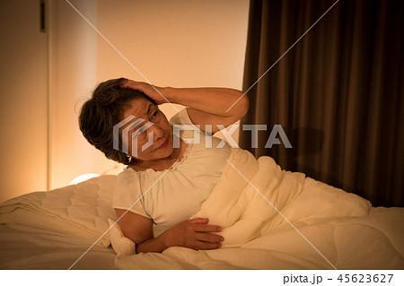 夜中に目が覚めるシニア女性　不眠症　寝苦しい 45623627