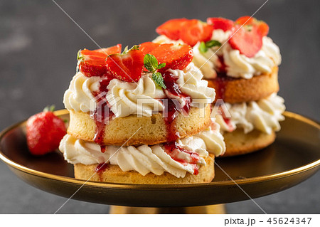 Victoria sponge cake with strawberries, jam and whipped cream on dark background. Copy space. Victoria sponge cake with strawberries, jam and whipped cream on dark background. Copy space. 45624347