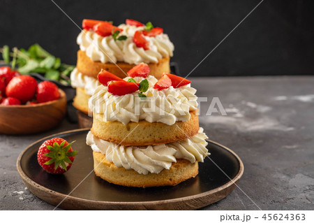 Victoria sponge cake with strawberries, jam and whipped cream on dark background. Copy space. 45624363