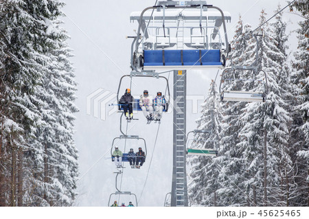 People with ski lifting on ski-lift in mountains People with ski lifting on ski-lift in mountains 45625465