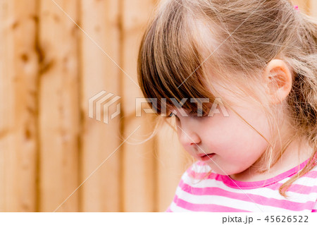 A young girl looking down contemplatively 45626522