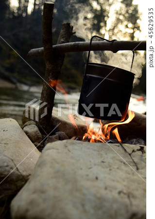 Cooking food in pot over campfire outdoor Cooking food in pot over campfire outdoor 45629535