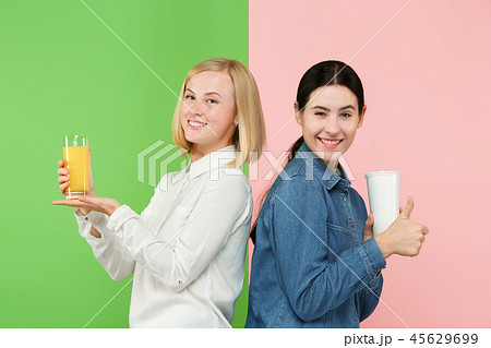 Diet. Dieting concept. Healthy Food. Beautiful Young Women choosing between fruit orange juice and Diet. Dieting concept. Healthy Food. Beautiful Young Women choosing between fruit orange juice and 45629699