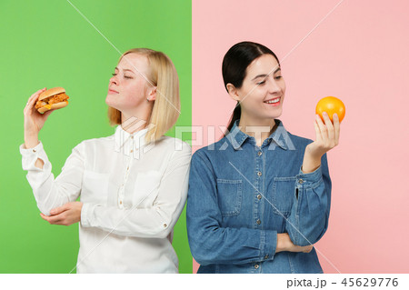 Diet. Dieting concept. Healthy Food. Beautiful Young Women choosing between fruits and unhelathy Diet. Dieting concept. Healthy Food. Beautiful Young Women choosing between fruits and unhelathy 45629776