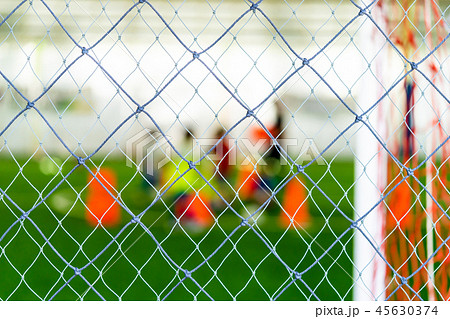 Soccer net blur on training ground with children Soccer net blur on training ground with children 45630374