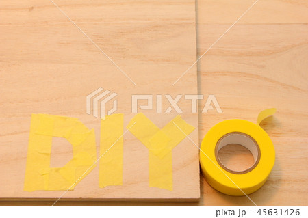 木の板の上にマスキングテープで書かれた「DIY」の文字。 45631426
