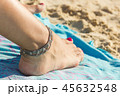 Ankle bracelet on foot with nail polished on beach 45632548