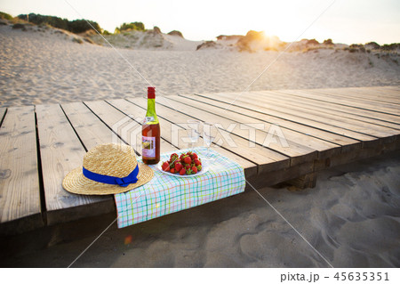 picnic near the sea-hat, wine, glasses, strawberry picnic near the sea-hat, wine, glasses, strawberry 45635351