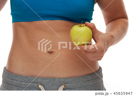 Woman with sportive body holding a fresh apple 45635947