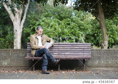 公園のベンチで本を読む男性 45636567