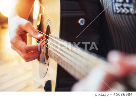 Guitarist plays guitar on wooden background, close up Guitarist plays guitar on wooden background, close up 45636984
