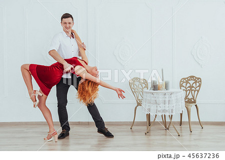 Young beautiful woman in a red dress and a man dancing, isolated on a white background. Young beautiful woman in a red dress and a man dancing, isolated on a white background. 45637236
