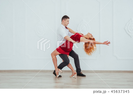 Young beautiful woman in a red dress and a man dancing, isolated on a white background. Young beautiful woman in a red dress and a man dancing, isolated on a white background. 45637345