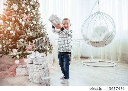 A child with a gift in a beautiful bright studio. A child with a gift in a beautiful bright studio. 45637471