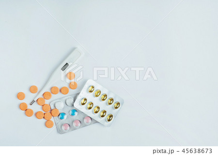 Flu. Thermometer with elevated temperature and many pills on light background Flu. Thermometer with elevated temperature and many pills on light background 45638673