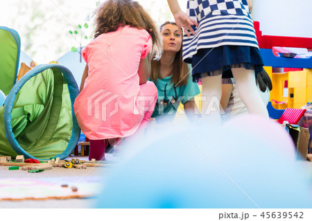 Dedicated kindergarten teacher coordinating a fun activity for kids 45639542